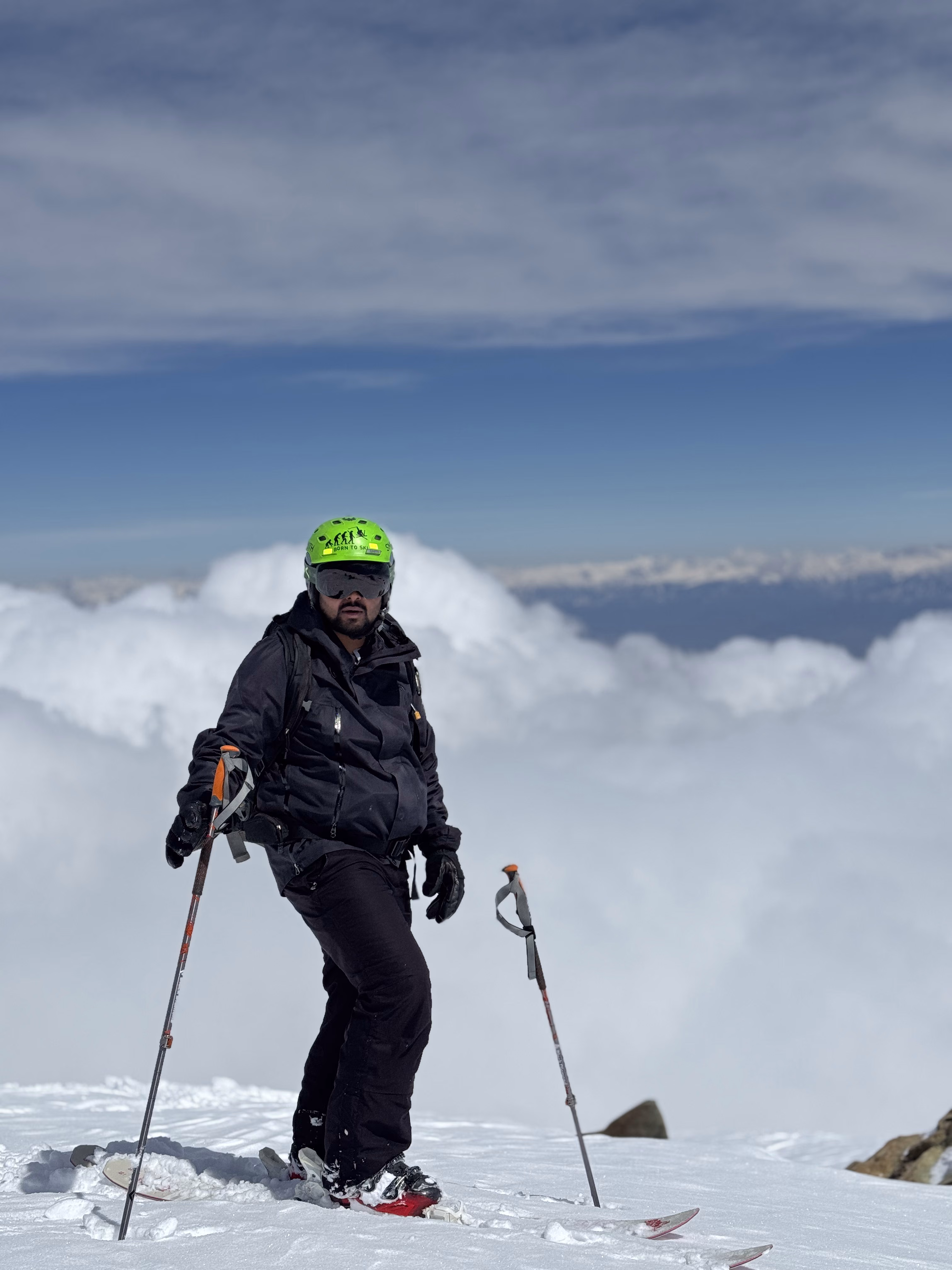 Skier at a Gulmarg summit with Himalayan peaks behind