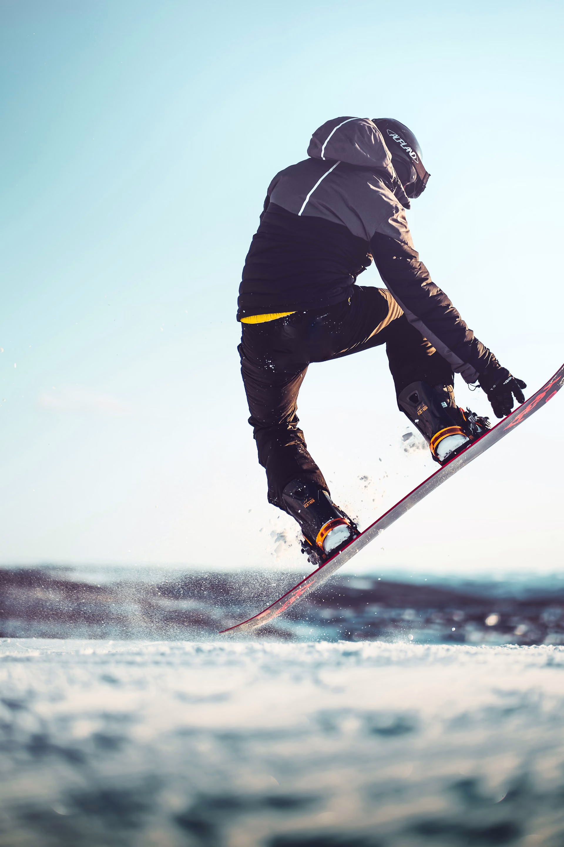 Snowboard and bindings close up as a rider turns through snow